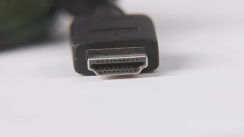 Black HDMI end of cable in slo mo white table surface 4k Stock Footage 329708342