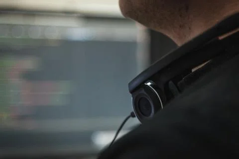Black headphones on the neck of programmer in the it office. Blurred monitor  Stock-Fotos