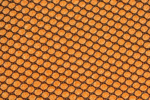 Black hex mesh on an orange sponge background Foto stock