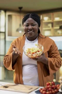 Black home chef vlogger creating detailed cooking tutorial in bright kitchen Stock-Fotos