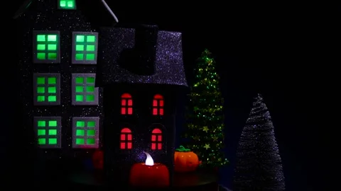 A black house rotates, surrounded by glowing candles and pumpkins Stock Footage 319264247