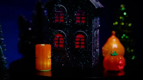A black house surrounded by glowing pumpkins and candles rotates Stock Footage 319293562