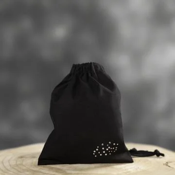A black hygiene draw-string bag with small fancy crystals, displayed on a woo Stock Photos