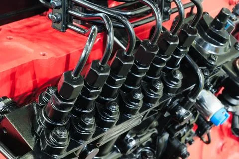 Black ignition coils connect to the engine. Red engine block shows metal comp Fotos de archivo