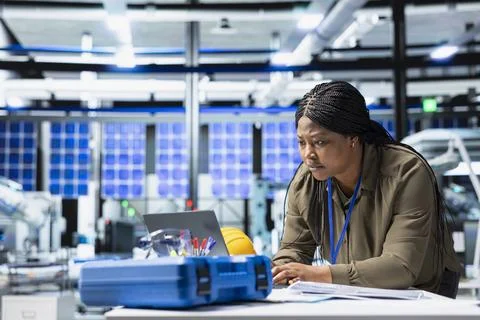 Black industry expert checking data on pc at the solar panel facility Stock Photos