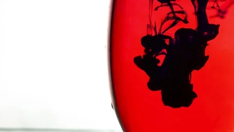 Black ink drop in red background Stock Footage 97349458