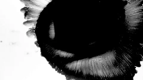 Black ink drops splatters spilling on white background Stock Footage 125469280