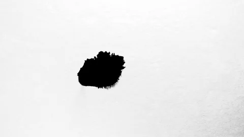 Black ink drops splatters spilling on white background Stock Footage 125470722