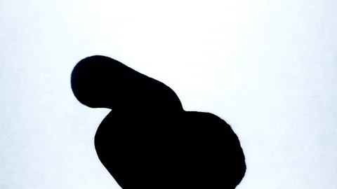 Black ink drops splatters spilling on white background Stock Footage 125471204