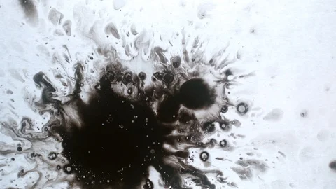 Black ink drops splatters spilling on white background Video stock 125472052