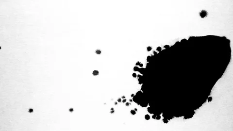 Black ink drops splatters spilling on white background Stock Footage 125472373