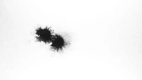 Black ink drops splatters spilling on white background Stock Footage 125472610