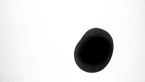 Black ink drops splatters spilling on white background Stock Footage 125473371