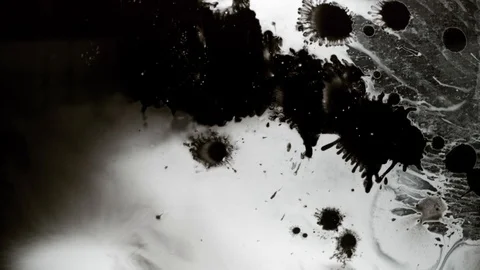 Black ink drops splatters spilling on white background Stock Footage 125476803