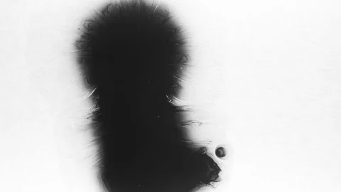 Black ink drops splatters spilling on white background Video stock 125477146