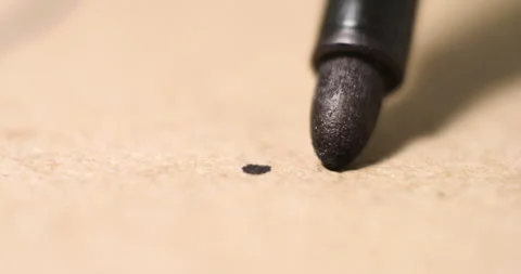 Black ink marker draws precise lines on kraft paper in closeup tracking shot Stock Footage 308453897