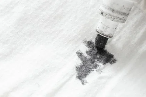 Black ink marker tip, scribbling on white fabric Stock Photos