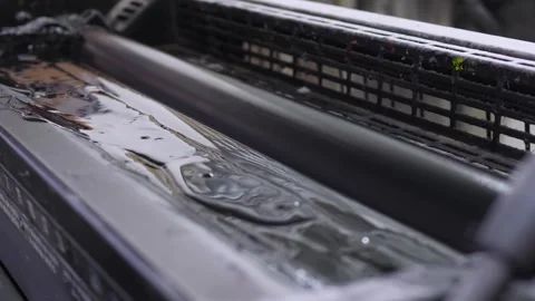 Black ink rollers inside offset printing press spreading dark pigment Stock Footage 321540017