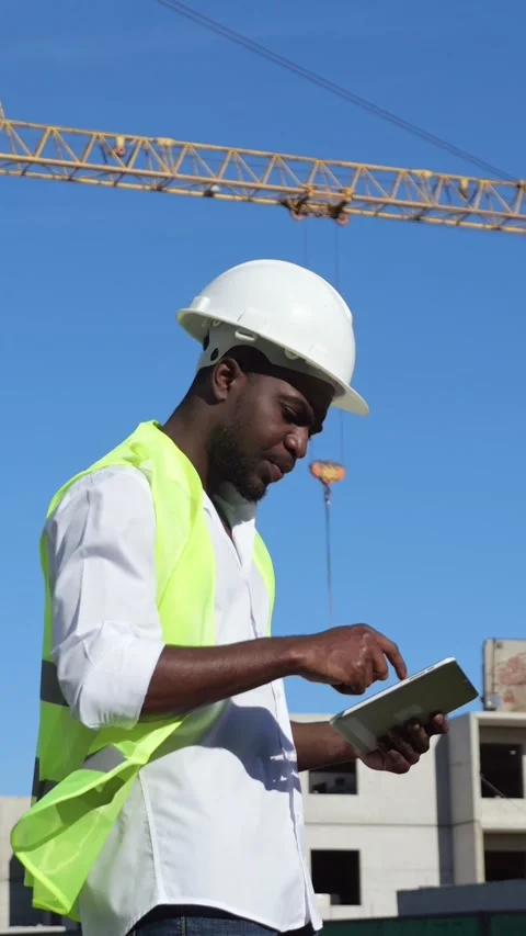 Black Inspector Using Tablet Construction Site, Wearing Hard Hat And Neon Vest Stock-Footage 333896895