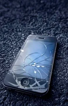 Black iphone  with broken display laying on asphalt Stock Photos