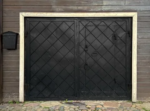 Black iron gates with waffle pattern in the form of a diamond. Stock Photos
