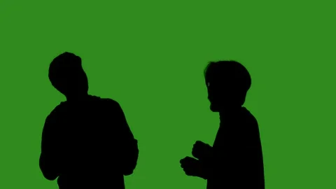 Black isolated silhouettes of two men dancing cheerfully on a green chroma key Stock Footage 334170287