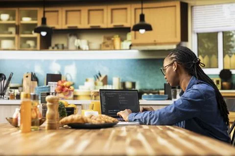 Black IT engineer working remotely, coding on laptop, programming scripts 스톡 사진