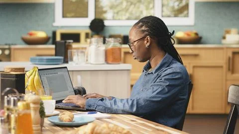 Black IT engineer working remotely coding on laptop and programming scripts Stock-Fotos