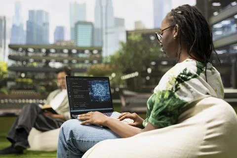 Black IT engineering student using AI and binary code on laptop Stock Photos