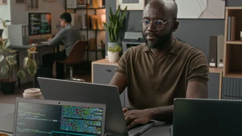 Black IT Specialist Coding and Adjusting Glasses while Working at Office Table Stock Footage 329611015