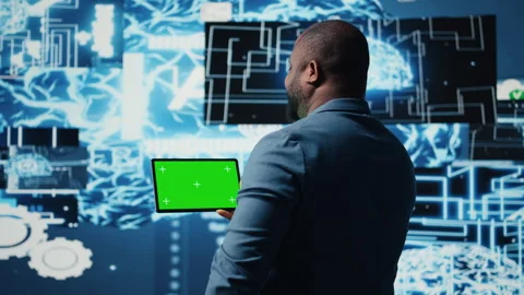 Black IT specialist examining algorithmic data next to chroma key Stock Footage 312414172