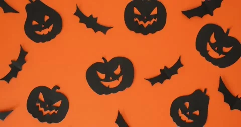 Black jack-o'-lanterns and bats pattern on an orange background Stock Footage 344980586