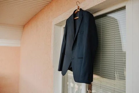 A black jacket hangs against a white window in the room. Stock Photos