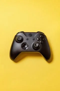 Black joystick on yellow background. Computer gaming competition videogame co Stock Photos