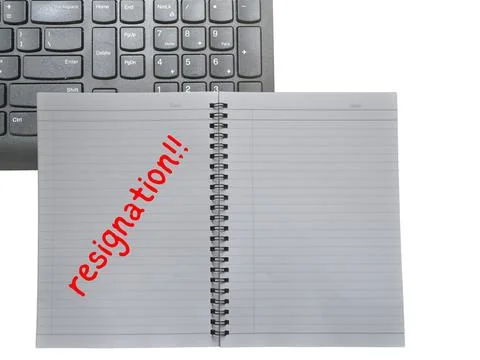 A black keyboard and a book note with the word "resignation" are set agains.. Fotos de archivo