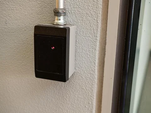 Black keycard reader outside of a entryway with red light Stock Photos