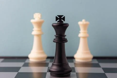 Black king standing between two white kings on chessboard symbolizing compe.. Stock Photos