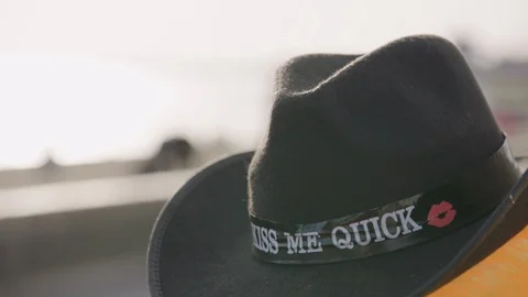 Black kiss me quick hat for sale at the promenade at the seaside Stock Footage 129692477