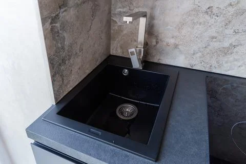 Black kitchen sink with single handle mixer installed in table Photos