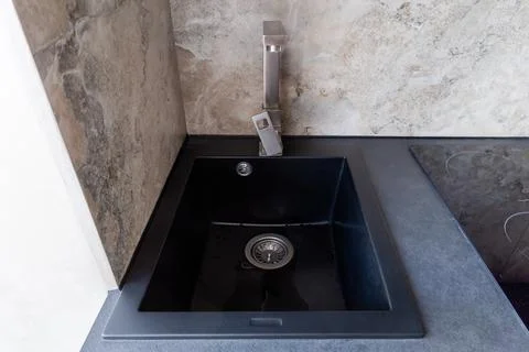Black kitchen sink with single handle mixer installed in table Photos