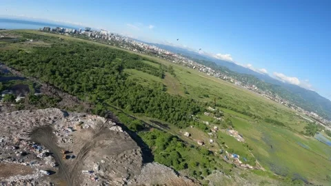 Black kite (bird) flying over river and forest, mountains and city background Stock Footage 201084313