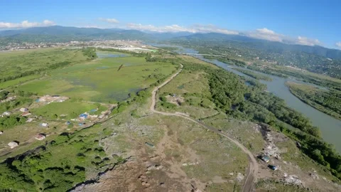 Black kite (bird) flying over river and forest, mountains and city background Stock Footage 201085356