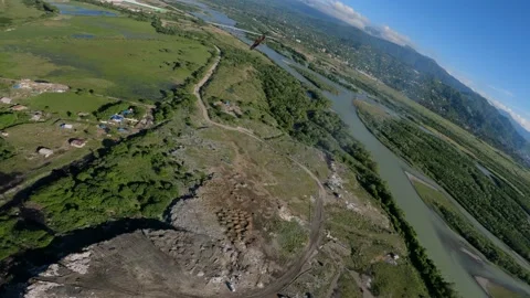 Black kite (bird) flying over river and forest, mountains and city background Stock Footage 201085440