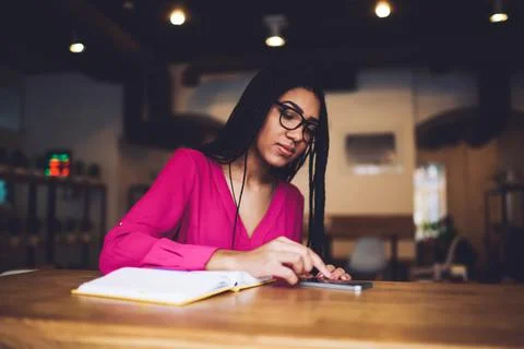 Black lady browsing smartphone while having break in cafe Stock Photos