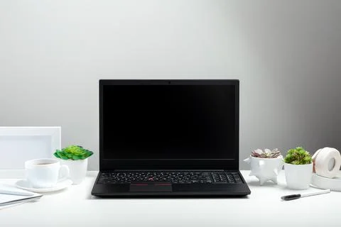 Black laptop with blank display layout template on white background. Office desk Foto stock