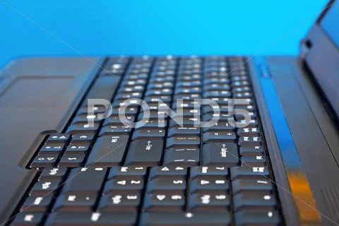 Black laptop on blue background. Shallow DOF Stock Photos