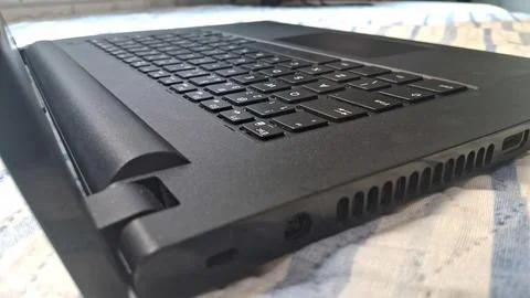 Black laptop computer keyboard resting on a soft textured bed surface Stock Photos