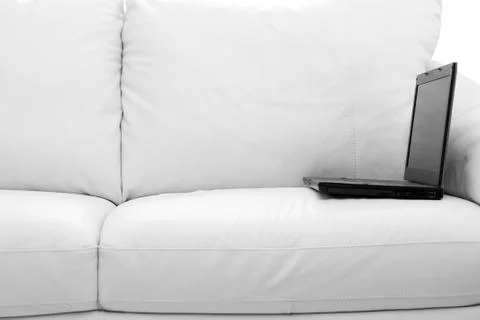 Black laptop computer on white sofa Stock Photos
