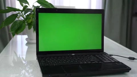 Black laptop with open green screen for mock up space stands on table Stock Footage 174886673
