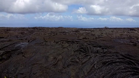 Black lava flow plain clouds hawaii recent destruction volcano Stock Footage 81755954